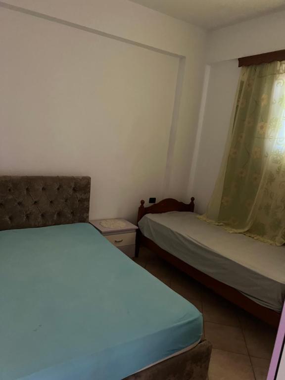 a bedroom with two beds and a window at Eljo Apartment in Asim Zeneli