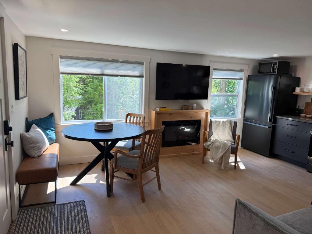 a living room with a table and a kitchen with a stove at Sunapee Getaway With Lake Access in Sunapee
