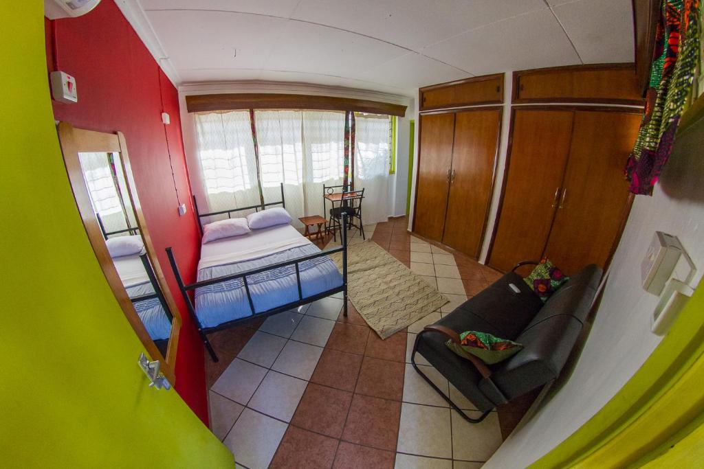 
a room with a bed, a couch, and a window at We Travel Hostel in Moshi

