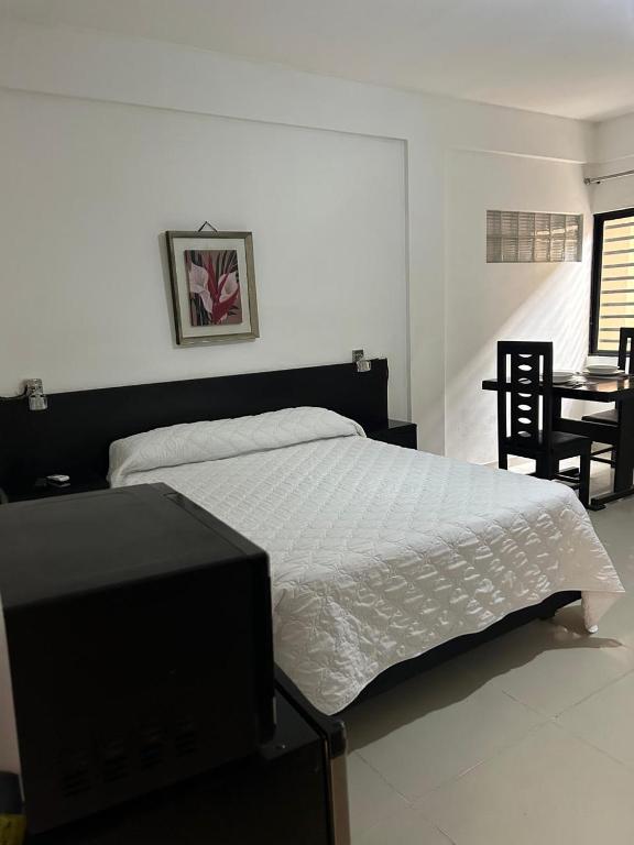 a bedroom with a bed and a table and chairs at X5 Condominio - Diagonal a Fexpocruz in Santa Cruz de la Sierra