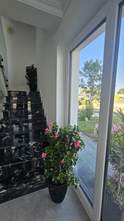 a room with a sliding glass door with flowers at White Villa in Darlowko