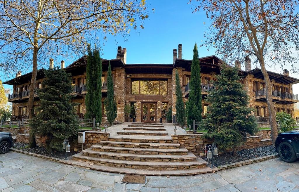 a large house with a staircase in front of it at Thermes Pozar Resort in Kato Loutraki