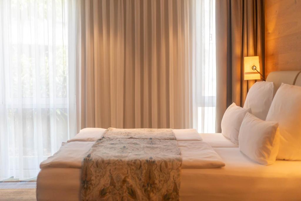 a bedroom with a bed with a table in front of a window at Berliner Hof Bed&Bike in Saint-Vith