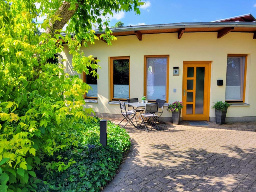 a house with a table and chairs in front of it at Heideberg Appartement in Zeuthen