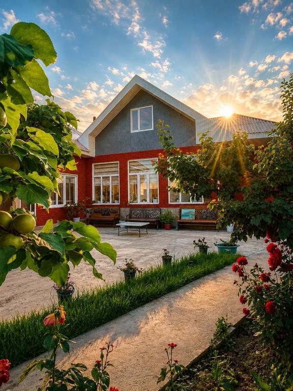 a house with a courtyard with a bench and flowers at Archa Ethno Guest House in Bokonbayevo