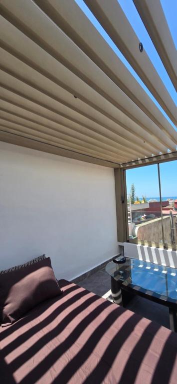 a bedroom with a bed and a large window at Cosy Duplex, Pool & Free Parking Steps to Beach in El Harhoura
