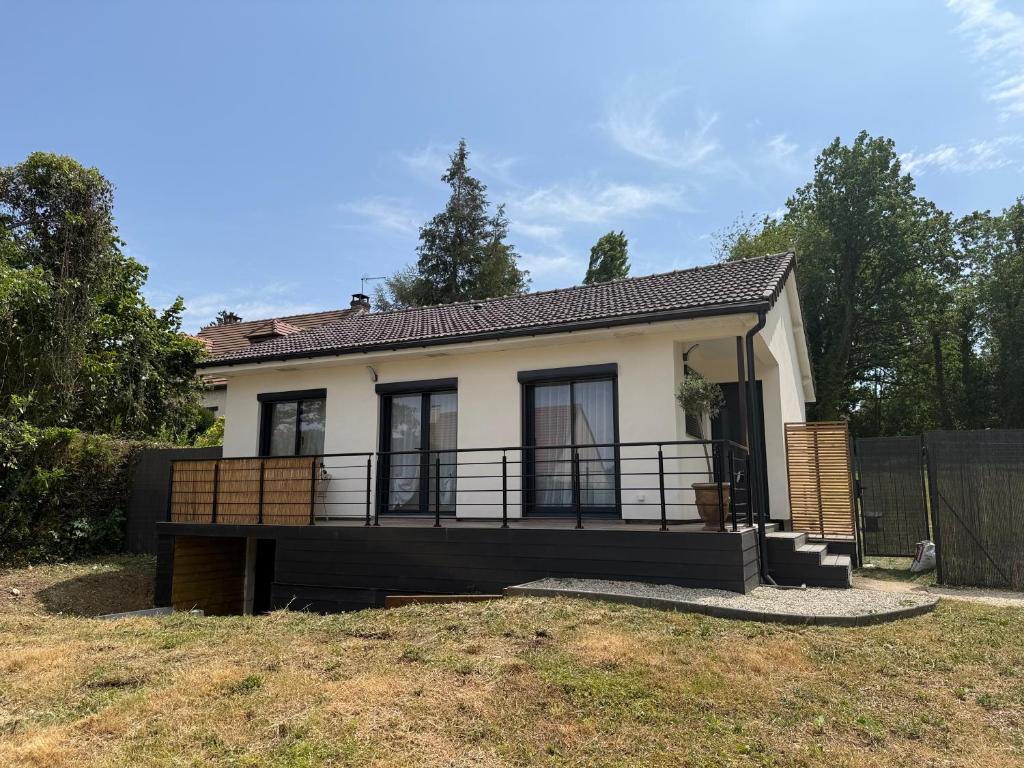 a small house with a large balcony in a yard at Le Balcon petit extérieur Idéal familles & couples à 10 min Disneyland Paris avec lit Queen size & parking privé in Coupvray