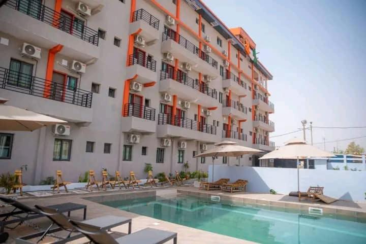 a hotel with a swimming pool in front of a building at Résidences Hôtel Nanga & Restaurant in Korhogo