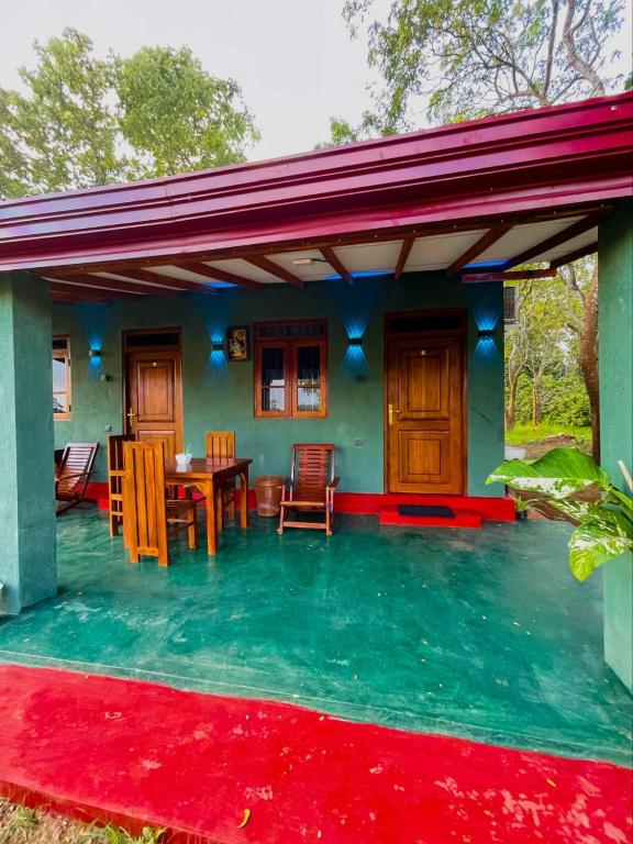 a patio with a table and chairs and a house at Green Haven - Wilpattu in Wilpattu