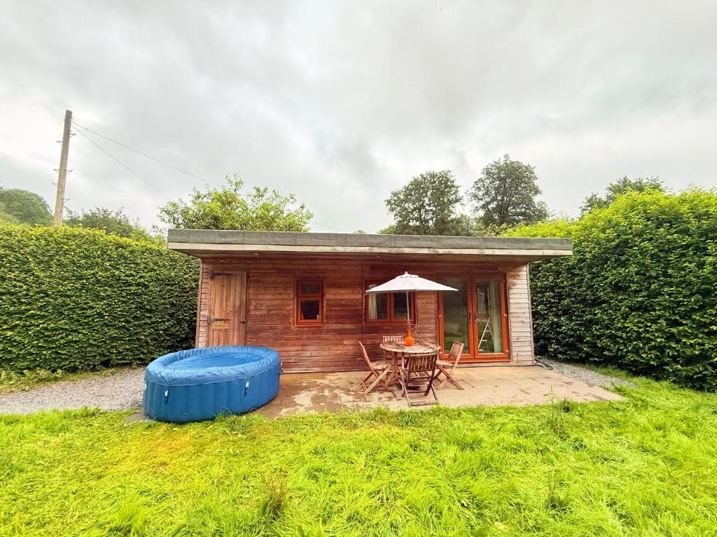 a small cabin with a table and a blue barrel at The Natures Nook With HotTub in Talog