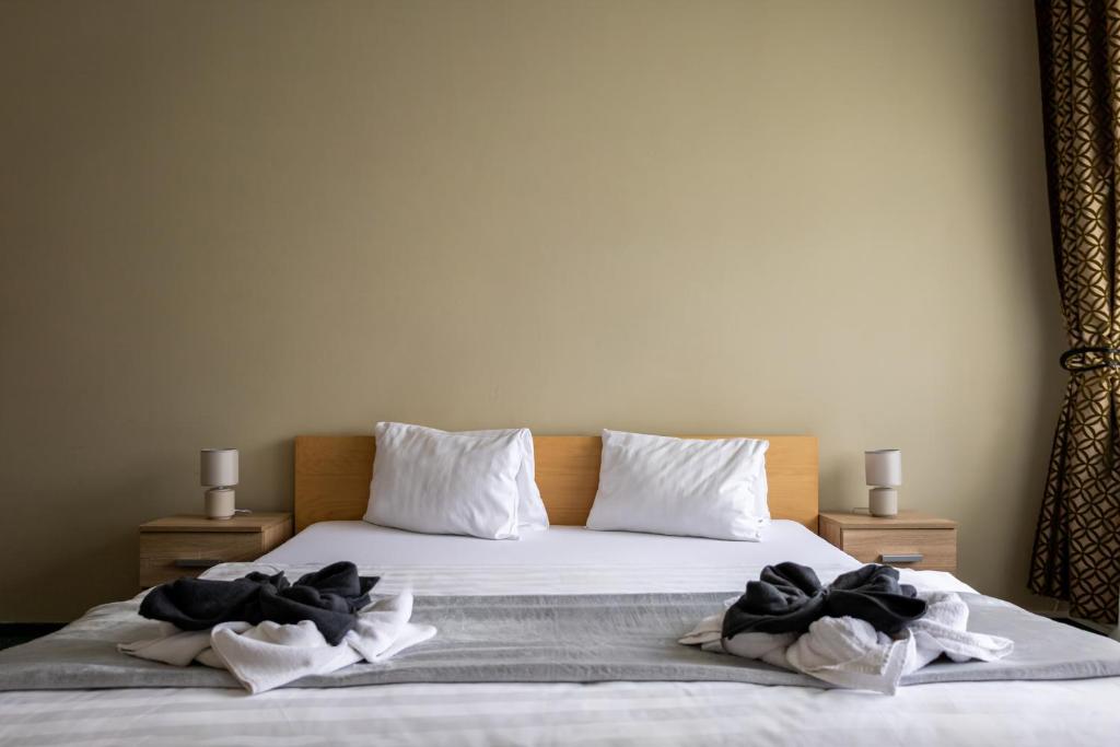 a bed with white sheets and black towels on it at Penzion Hubert Františkovy Lázně in Františkovy Lázně