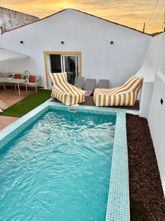 a swimming pool with two lounge chairs and a house at Casa Vila de Frades in Vila de Frades