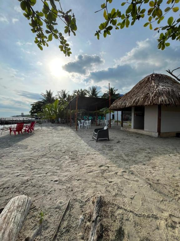 a beach with a hut and chairs on the sand at Hotel Boutique Primavera Beach in Necoclí