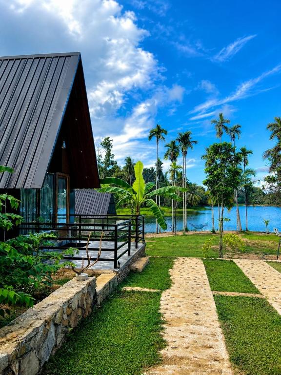 a house on the shore of a body of water at Jungle Lake View Cabana in Udawalawe