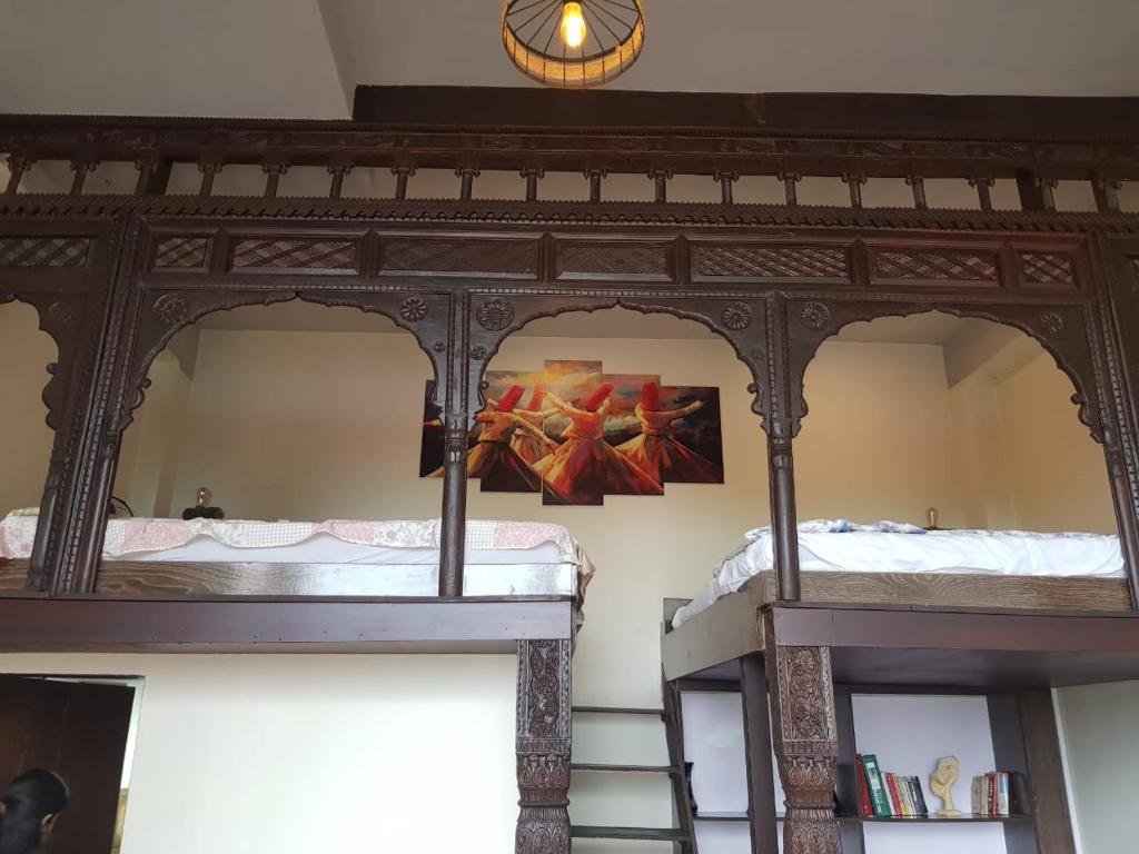 two bunk beds in a room with a painting on the wall at Saadis cottage in Bhurban