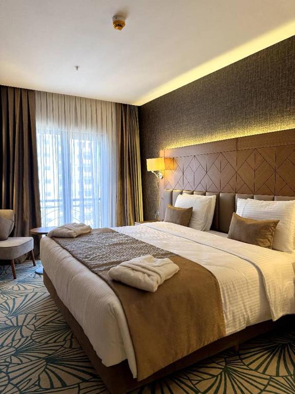 ein Hotelzimmer mit einem großen Bett, auf dem Handtücher lagen in der Unterkunft KBF Hotel in Alger