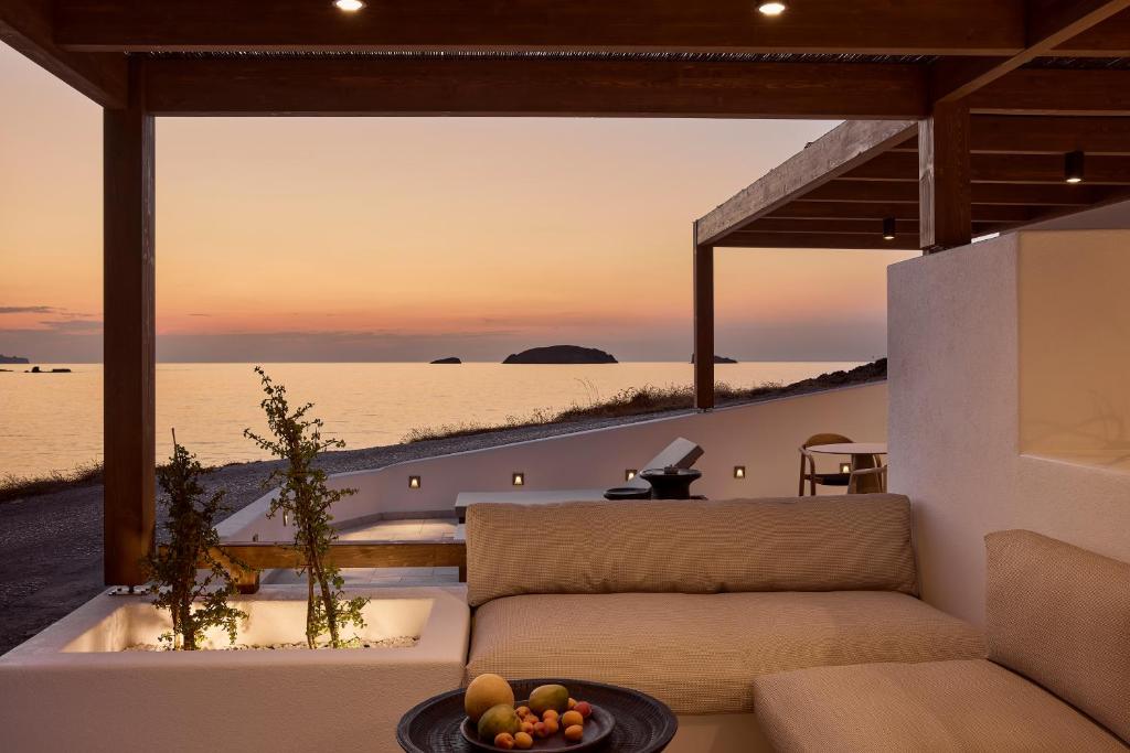 a living room with a couch and a view of the ocean at Ostraco Houses in Pachaina