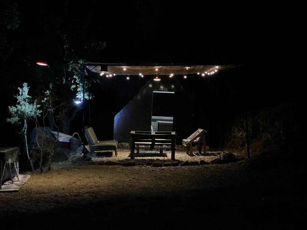 a picnic table and chairs under a tent at night at Kroom cabins in Bâne