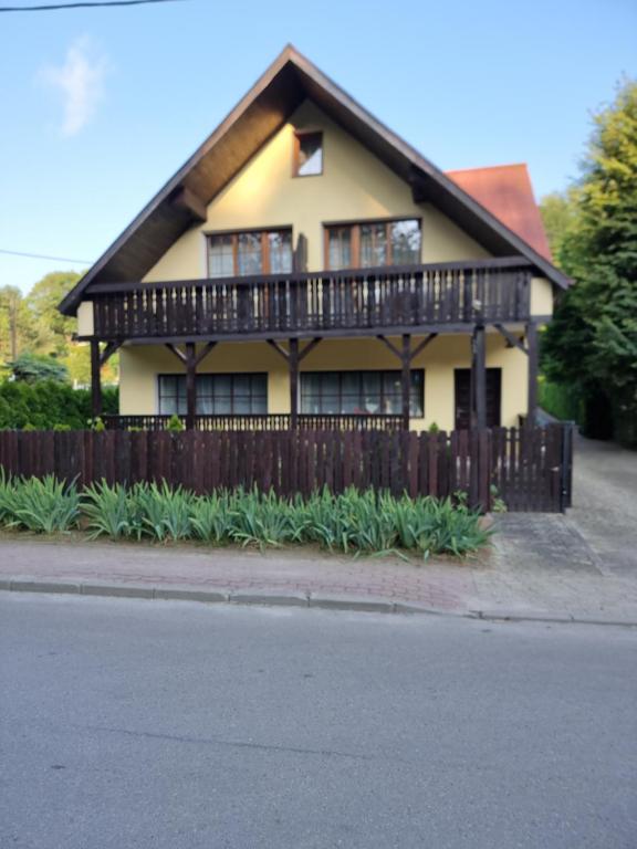 a house with a wooden fence in front of it at Pokoje Poniatowka in Nałęczów