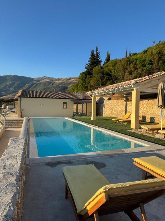 a swimming pool with a picnic table and a house at Kalesma Himare in Himare
