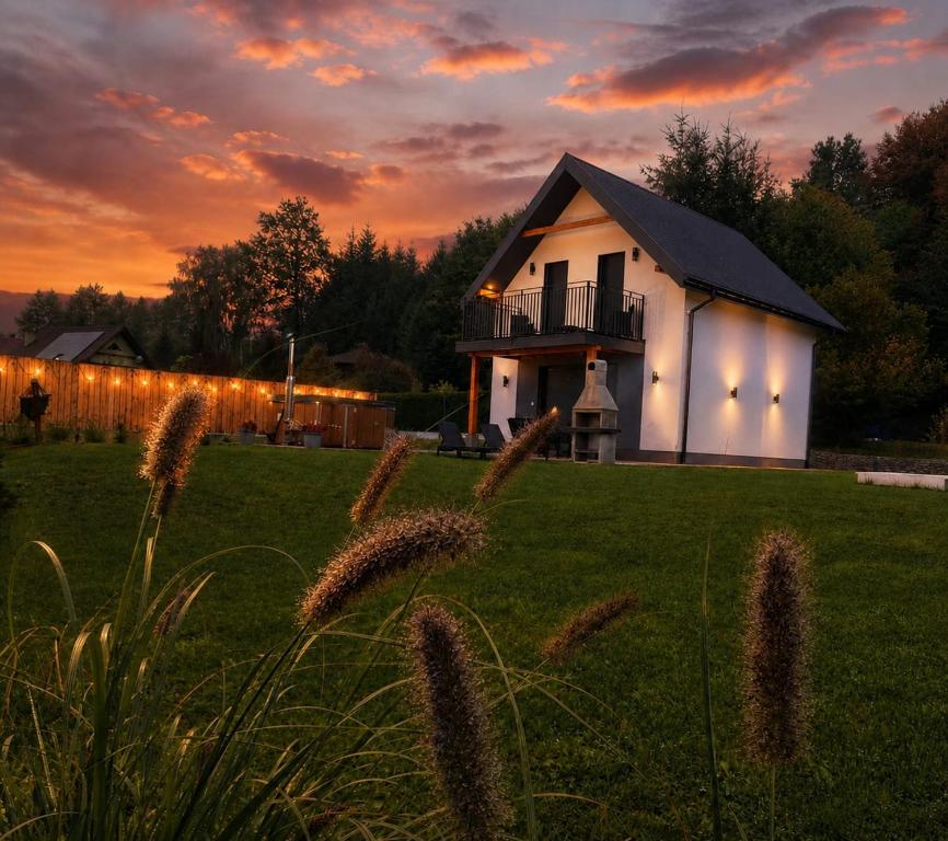 a house in a field with a sunset in the background at Jelonkowo in Brenna