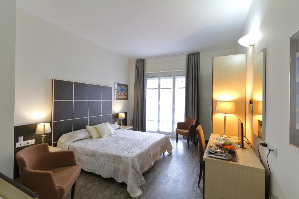 una camera con letto, tavolo e sedie di Hotel Ferrari a Chiavari
