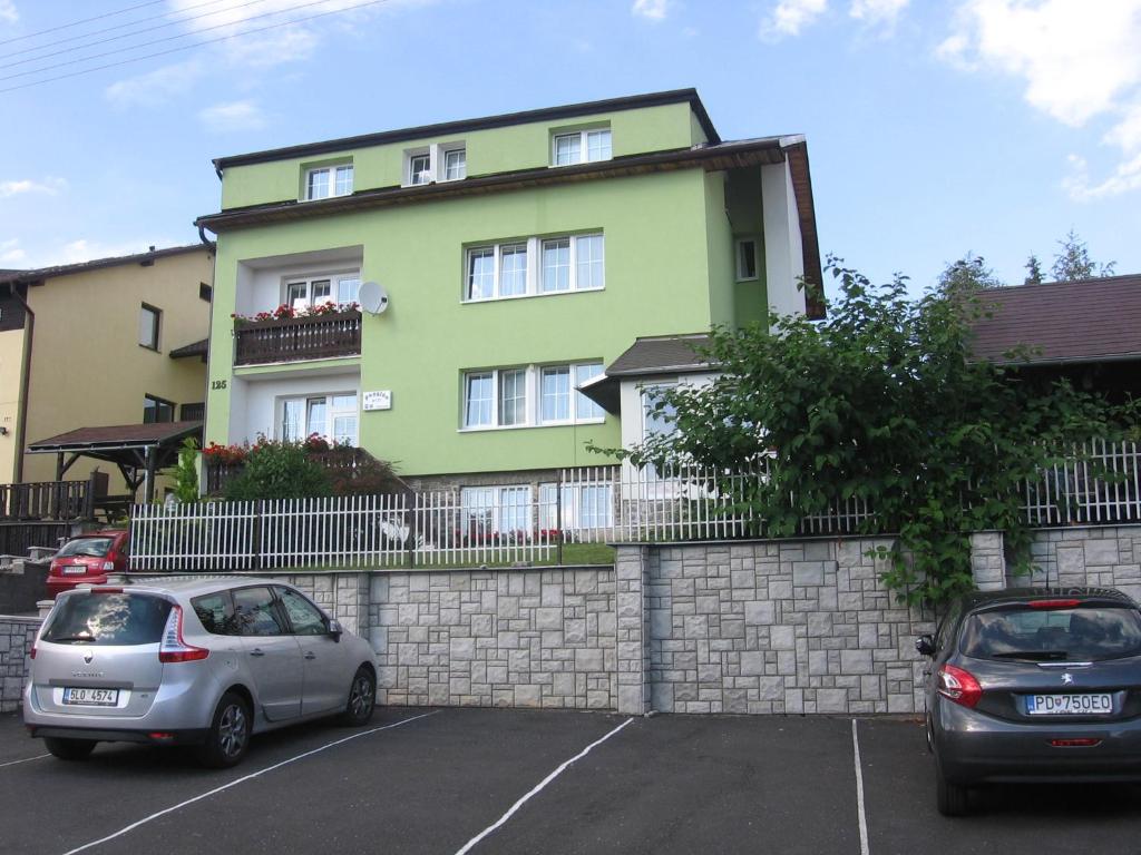 two cars parked in a parking lot in front of a building at Penzión Závada in Nová Lesná