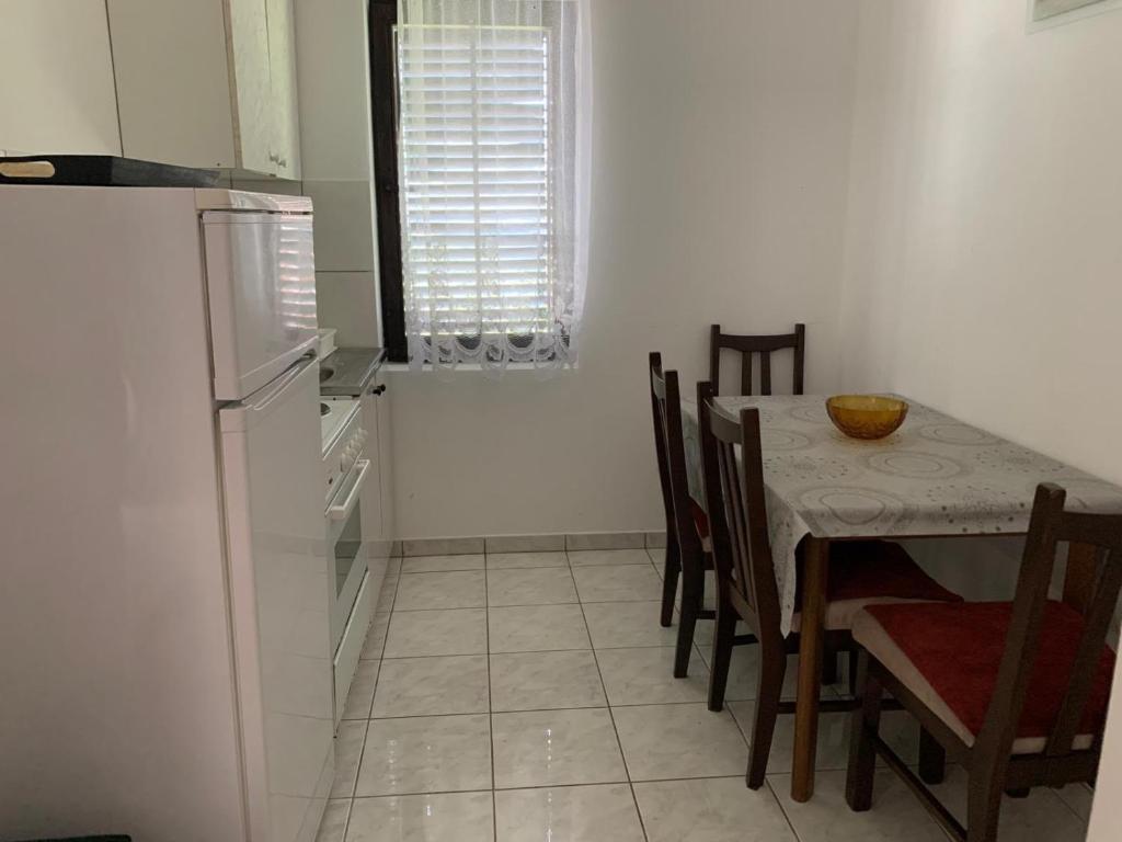 a kitchen with a table with chairs and a refrigerator at Hatex Retreat in Donji Štoj