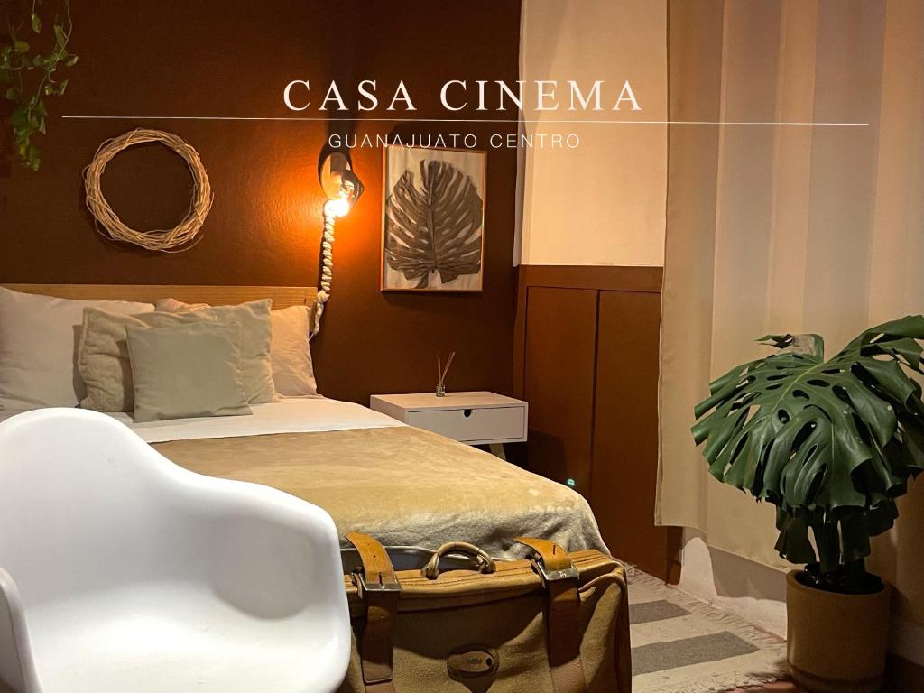 a bedroom with a bed with a chair and a plant at Galerie Guanajuato Centro in Guanajuato