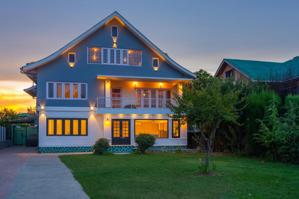 a large house with a sunset in the background at Blume House- 4BHK Holiday Home with Kitchen & Garden in Srinagar
