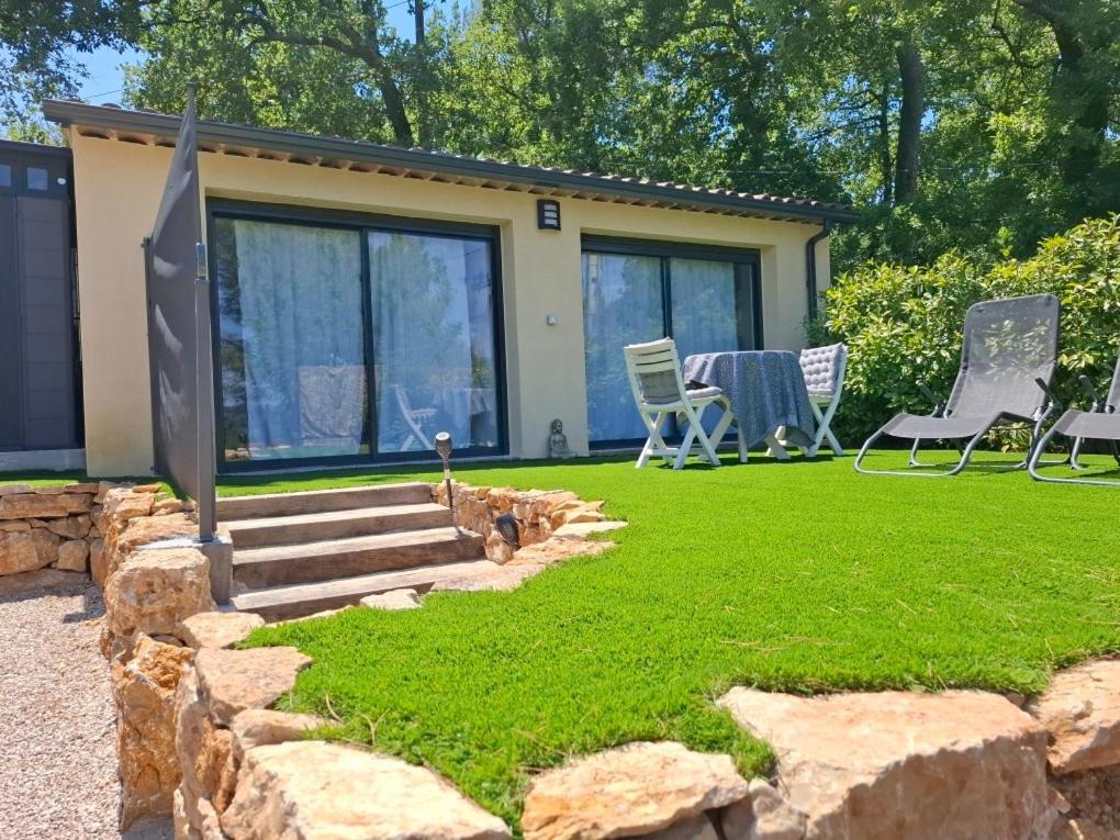 a yard with a house with chairs and a table at escapade coeur provence in La Celle