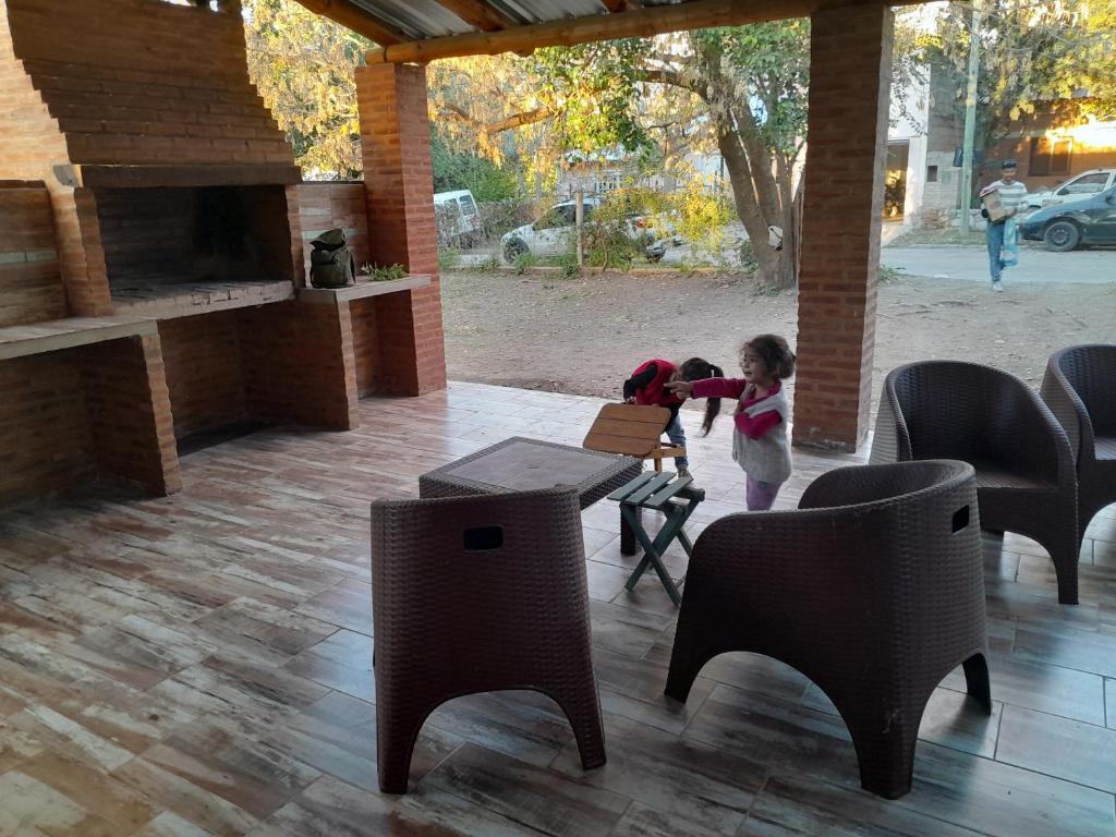 a little girl standing next to a table and chairs at Graciela in Villa Las Rosas