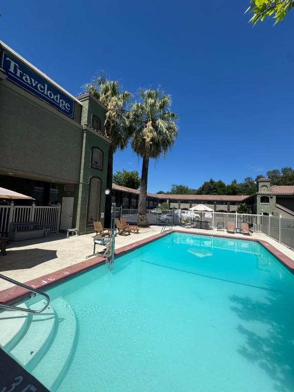 a large swimming pool in front of a hotel at Travelodge by Wyndham Redding CA in Redding