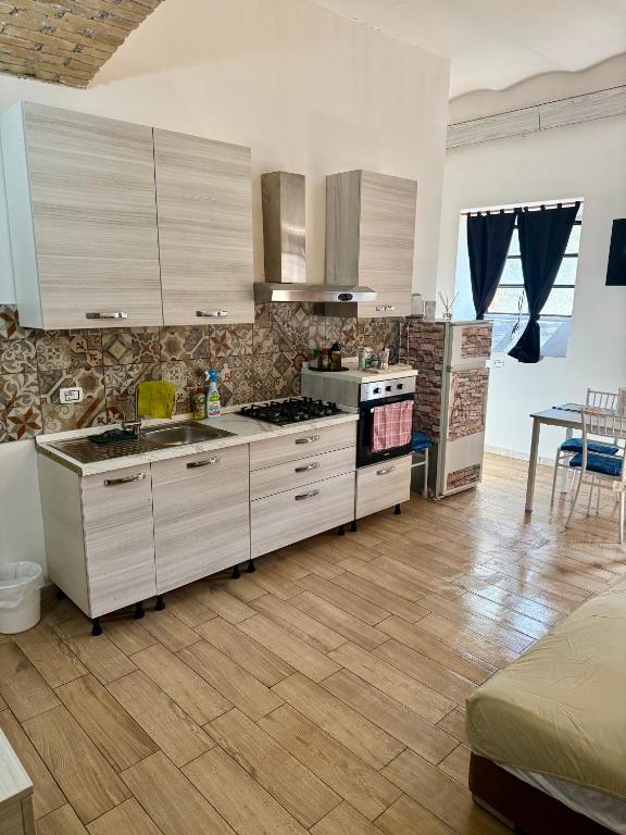 a kitchen with white cabinets and a stove top oven at Casale di Torvaianica in Campo Iemini
