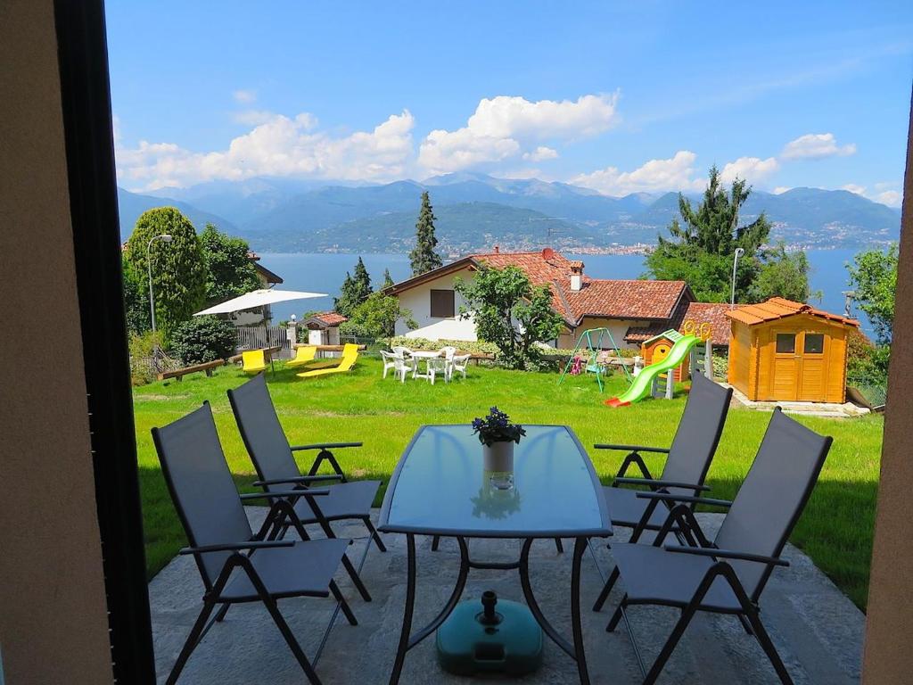 une terrasse avec une table et des chaises ainsi qu'une aire de jeux dans l'établissement Asia, à Stresa