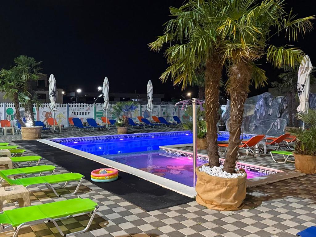 a pool with chairs and a palm tree in a resort at Hotel Atlantic Costinesti in Costinesti
