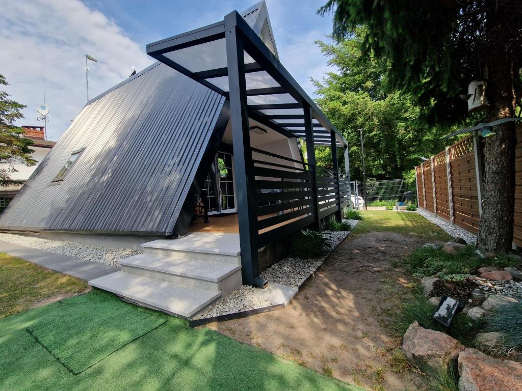 a house with a metal roof and stairs at Bukowy Domek Całoroczny in Sieraków