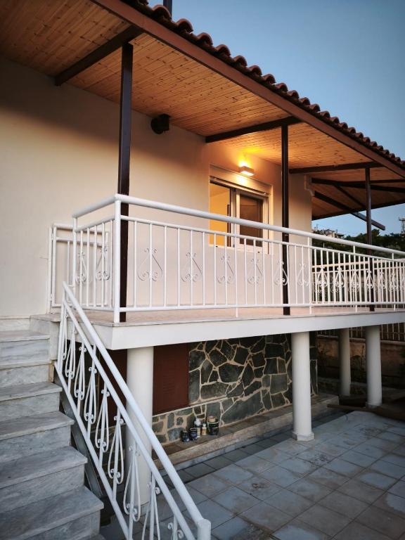 a house with a balcony and stairs in front at LagonisiSunsetHouse in Kalívia Thorikoú