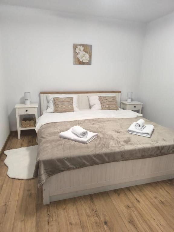 a bedroom with a bed with two towels on it at Aero Comfort Apartment in Cluj-Napoca