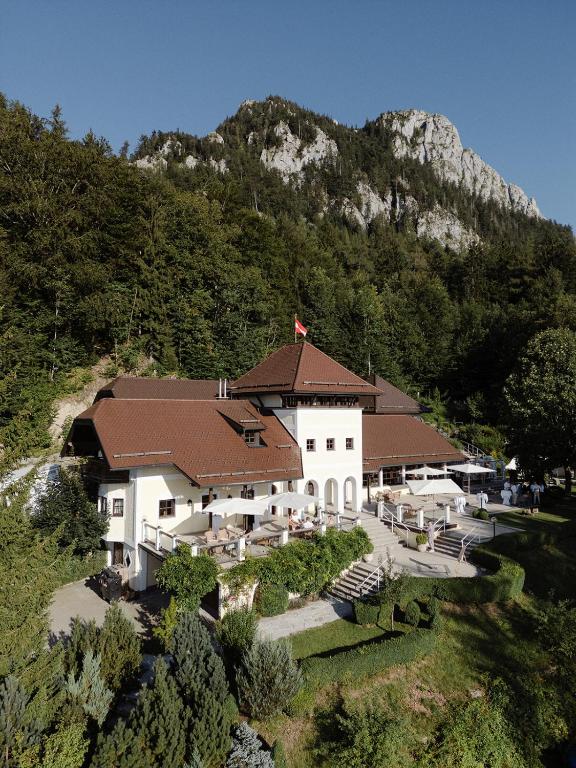 a large white building with a mountain in the background at Ansitz Wartenfels in Thalgau