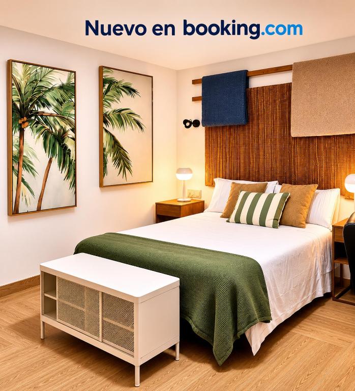 a bedroom with a large bed with a green blanket at HOTEL LOS ALAMOS BOUTIQUE in Plasencia