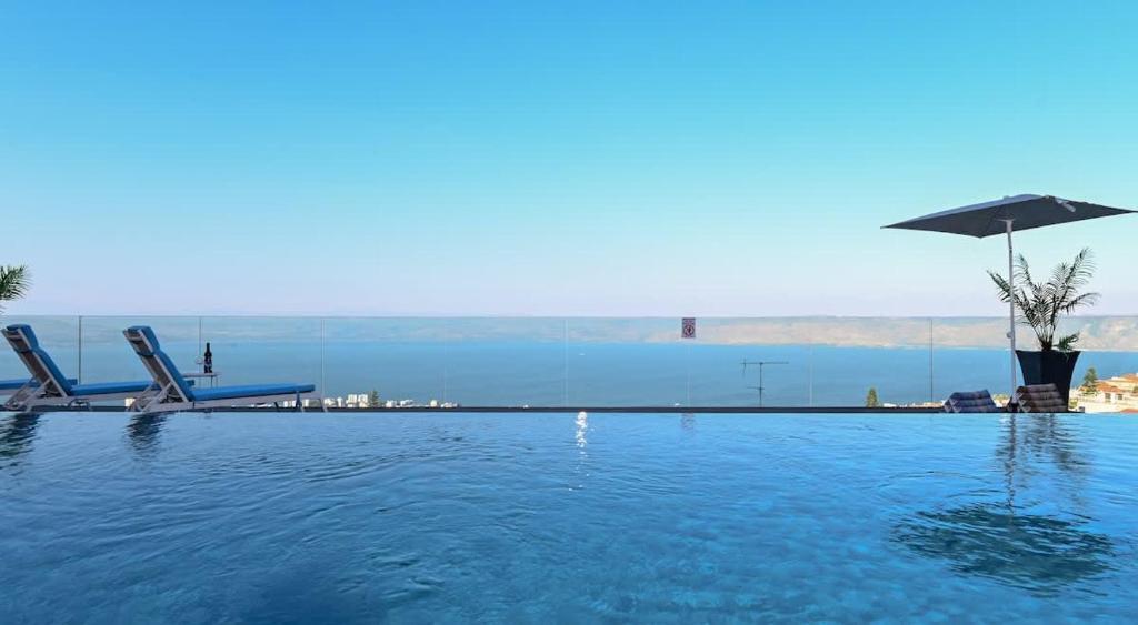 a swimming pool with a view of the water at חופש יהונתן-וילה סלביא עם נוף מטורף בריכה פרטית Hofesh Yehonatan Villa Selavi in Tiberias