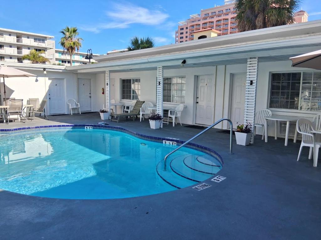 a swimming pool with a hose in front of a house at Tropical Sky Ranch Motel in Clearwater Beach