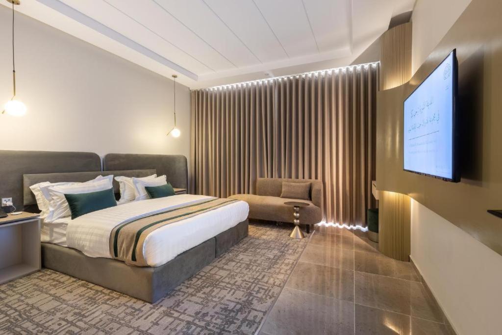 a bedroom with a bed and a flat screen tv at فندق فاتوران 2 in Medina
