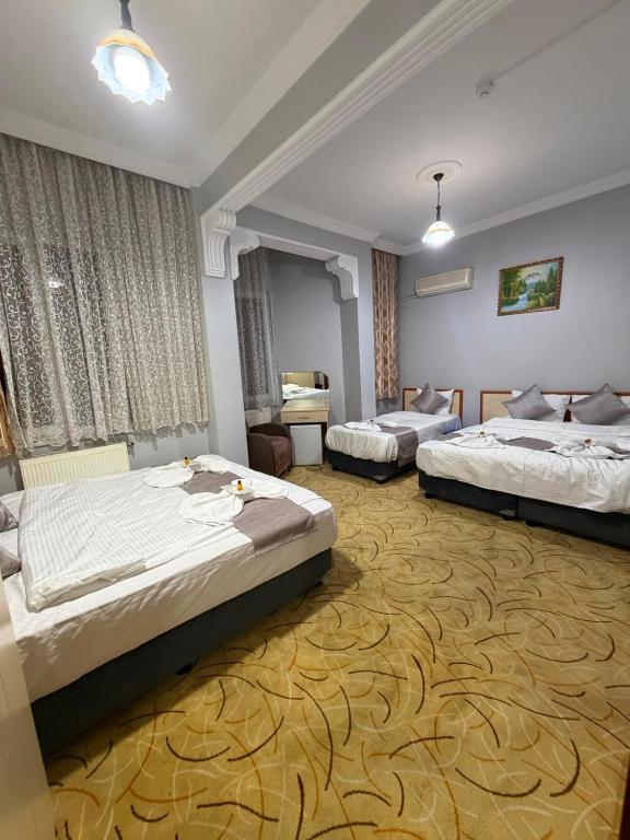 a hotel room with two beds and a desk at Grand Bazaar Hotel Merve in Istanbul