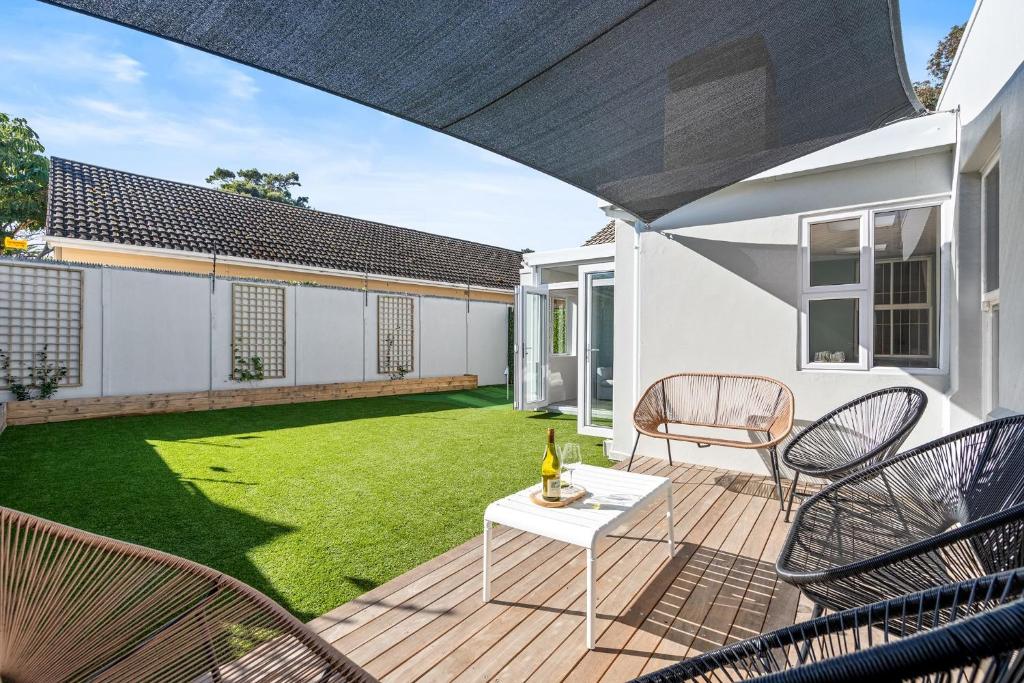 an outdoor patio with a lawn and chairs at Sangrove Residence in Cape Town