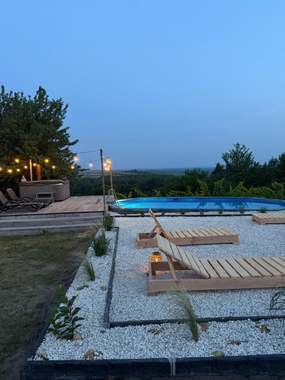 a patio with a hammock and a swimming pool at Widok i Wino Winnica Lipowiec in Lipowiec