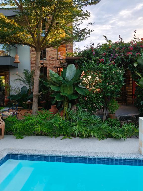 a swimming pool in a yard with trees and plants at Suíte Arvoredo in Saquarema