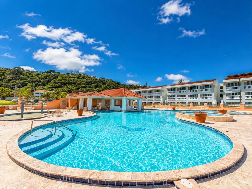 a swimming pool at a resort with a building in the background at Golden Villas 306B studio in Isabela