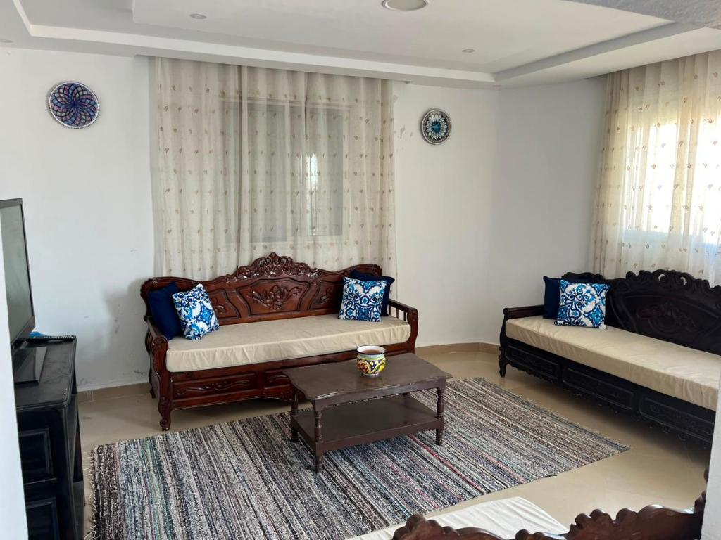 a living room with two couches and a table at sunset apartment in Kelibia